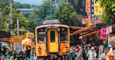 yellow train near building and people