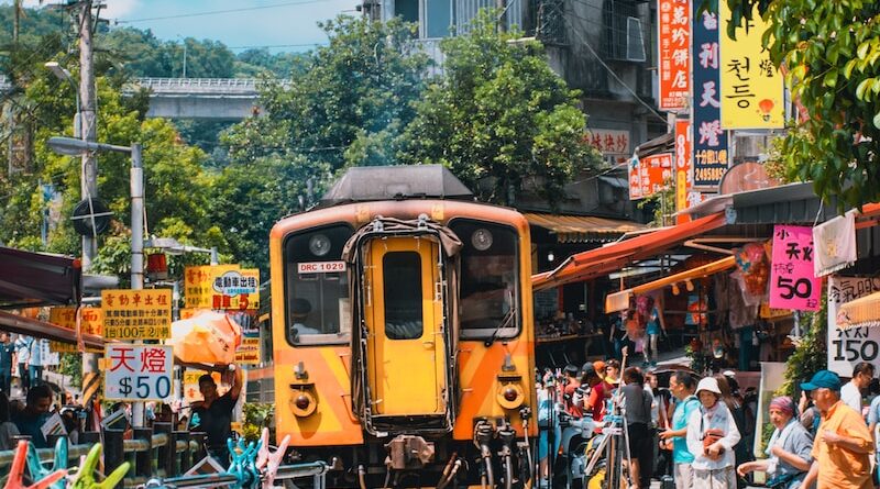 yellow train near building and people