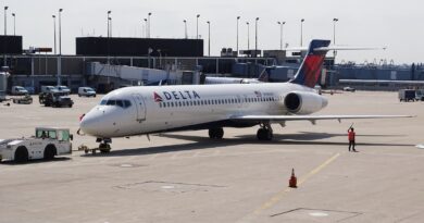 man standing beside white Delta airplane