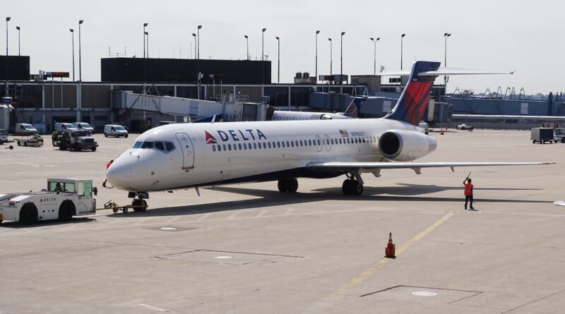 man standing beside white Delta airplane