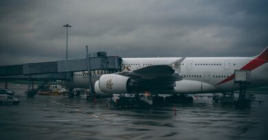 white and black airplane under cloudy sky