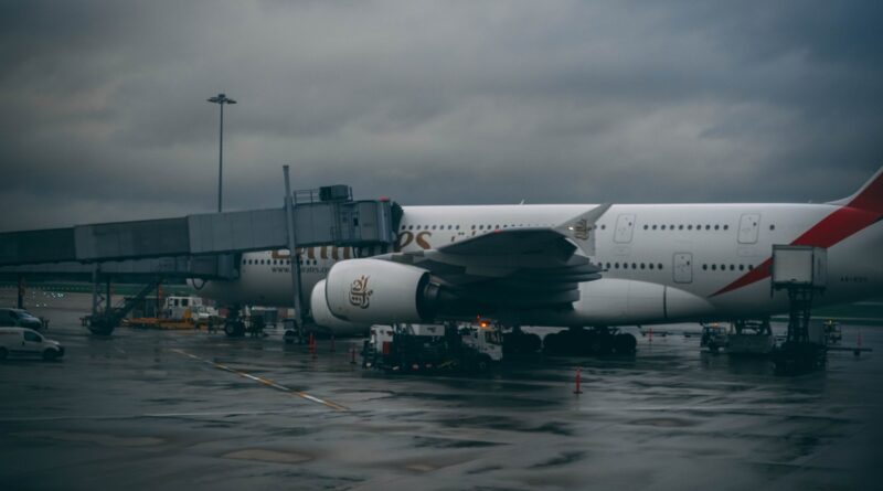 white and black airplane under cloudy sky
