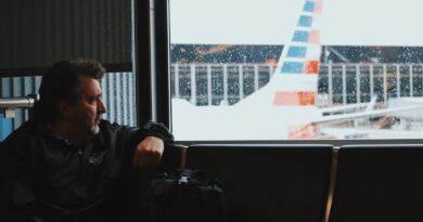 man sitting in airport watching airplane during daytime