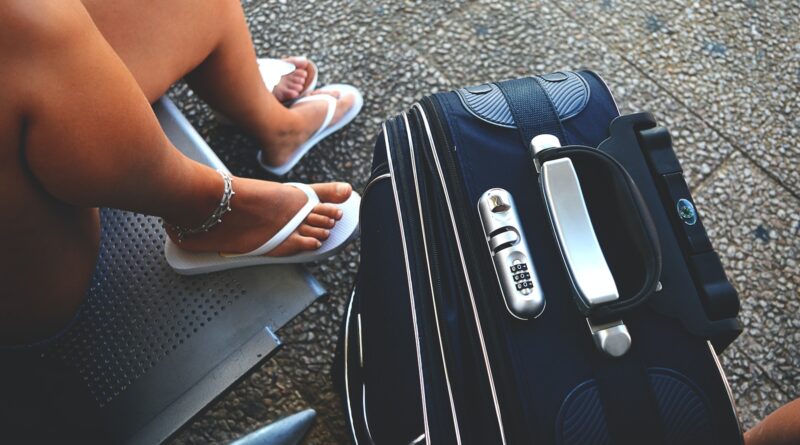 woman sitting on chair beside luggage bag